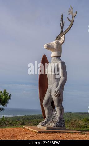 Statue für den Surfer am windigen Nordstrand des Surfens in Nazare, Austragungsort eines der weltweit größten Surfwettbewerbe mit 30 m Wellen, Nazare, Portugal, Stockfoto