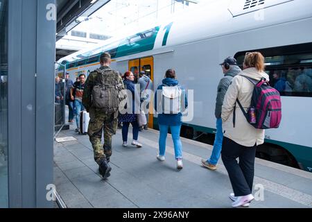 Regionalzug kommt am Berliner Bahnhof an, Passagiere, Militär im Urlaub warten auf Bahnsteig, Verspätung der öffentlichen Verkehrsmittel, tägliche Pendelfahrt, Berlin - April Stockfoto