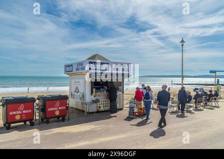 Bournemouth, Vereinigtes Königreich - 12. April 2024: Menschen um einen Kiosk am Middle Chine Beach. Stockfoto