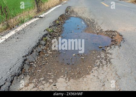 Asphaltdecke auf der Straße war aufgrund der schlechten Bau abgerissen. Stockfoto