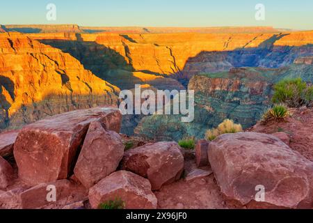 Geschichtete Klippen des riesigen Canyons, die durch die riesigen Felsen im Vordergrund gesehen werden. Stockfoto