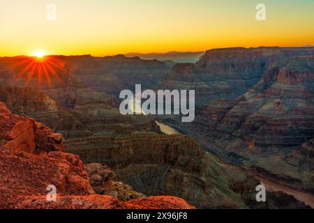 Grand Canyon bei Sonnenuntergang, wo das goldene Licht die gewundenen Fluss- und Felsformationen in warme Farbtöne taucht. Stockfoto