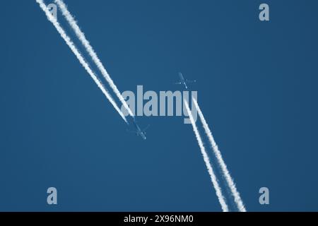 Zwei Flugzeuge am Himmel, zwei Flugzeugspuren am blauen Himmel, Kondensstreifen Stockfoto