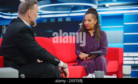 Talk Show TV-Programm, News Interview und Diskussion: Moderator und Gastgespräch. Kabelkanal-Hosts Führen Eine Freundliche Unterhaltung. TV-Studio und Newsroom Entertainment-Konzept Stockfoto