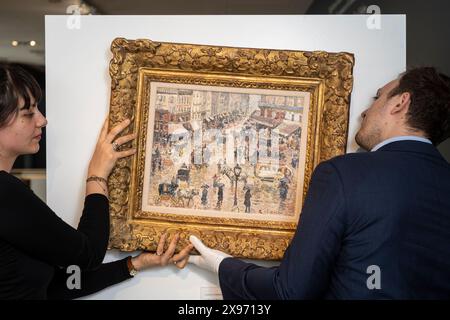 London, Großbritannien. 29. Mai 2024. Mitarbeiter hängen „La Place du Havre, Effet de Pluie“, 1897, von Camille Pissarro bei einer Vorschau von „Celebrating 150 Years of Impressionism“, einer Ausstellung impressionistischer und post-impressionistischer Werke in der Galerie Stern Pissarro in St. James Die erste impressionistische Ausstellung 1874, organisiert von Pissarro, Monet, Degas, Renoir, und Sisley brachte Werke von 31 Künstlern zusammen, die dafür bekannt waren, Landschaften und zeitgenössisches Leben en plein Air (außerhalb) zu malen, anstatt starre akademische Malerei. Die Show läuft vom 30. Mai bis zum 29. Juni 2024. Quelle: Stephen Chung / Stockfoto