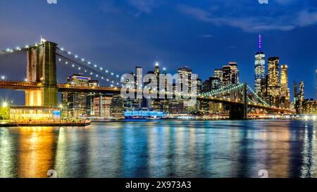 Brooklyn Bridge und Manhattan Skyline bei Nacht beleuchtet von der Brooklyn Heights Promenade in New York City Stockfoto