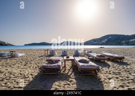 IOS, Griechenland - 2. Mai 2024 : Blick auf Sonnenliegen, Strandsofas und Tische am wunderschönen Strand von Gialos in iOS Griechenland Stockfoto