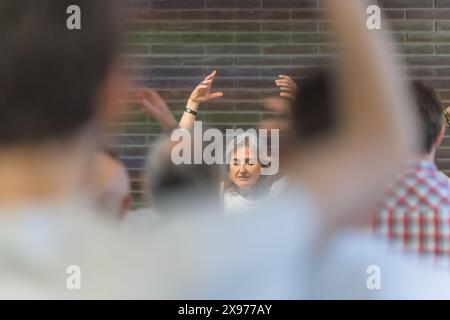 Frau, die eine Gruppe von Menschen dazu führt, ein spirituelles Konzept der Meditation zu erreichen Stockfoto