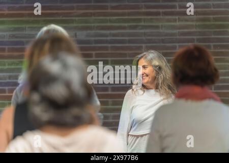 Glückliche Frau bei einer Konferenz mit einer Gruppe von Senioren Stockfoto