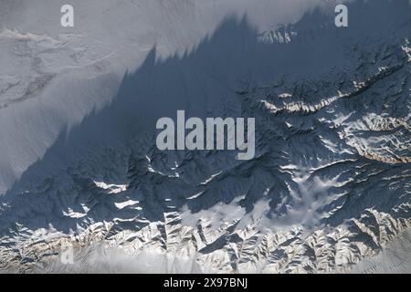 27. Mai 2024 – Mongolei – während eines Umkreises über die Zentralmongolei nahm ein Astronaut an Bord der Internationalen Raumstation (ISS) dieses Bild der schneebedeckten Gobi-Altai-Berge und benachbarten Ebenen auf. Am späten Nachmittag wirft das Sonnenlicht lange Schatten von Berggipfeln auf die Ebenen darunter. Zahlreiche steile Schluchten, die in das Massiv eingeschnitten sind, oder eine Masse von Bergen, deren raues Aussehen sich von den flachen Ebenen abhebt, die sich entlang des oberen Bilds erstrecken. Die Ebene ist eine Halbwüstengraswiesen oder Steppe, die Viehhirten in der Region als Weide dient. Ein Teil eines kleinen, trockenen Sees erscheint im Stockfoto