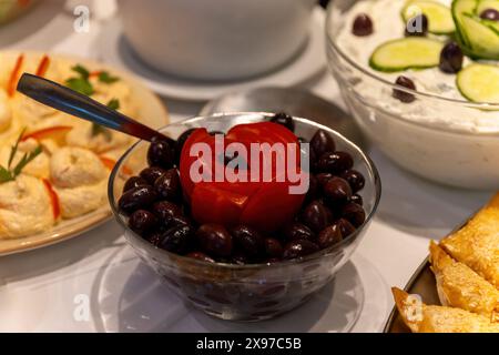 Oliven in einer Glasschale, dekoriert mit Tomaten Stockfoto