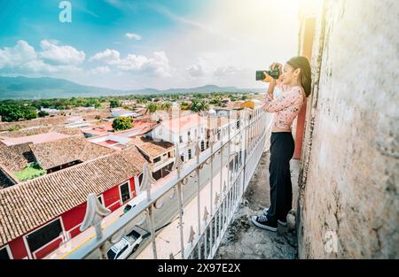 Touristen fotografieren die Straßen von Granada vom Aussichtspunkt La Merced. Touristenmädchen, das Fotos vom Dach der Kolonialhäuser in Granada macht Stockfoto