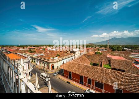 Blick von oben auf die Fassade einiger farbenfroher Kolonialgebäude in der Stadt Granada. Blick auf die gekachelten Dächer der farbenfrohen Gebäude in Granada Stockfoto