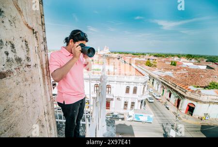 Touristen fotografieren die Straßen von Granada vom Aussichtspunkt La Merced. Touristenmann, der Fotos vom Dach der Kolonialhäuser in Granada macht Stockfoto