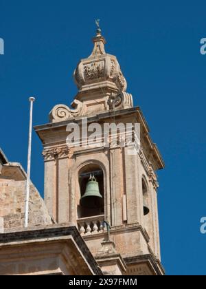 Detaillierter Blick auf einen barocken Glockenturm mit Dekoration und blauem Himmel im Hintergrund, historische Gebäude mit schönen Fenstern, Balkonen und kleinen Stockfoto