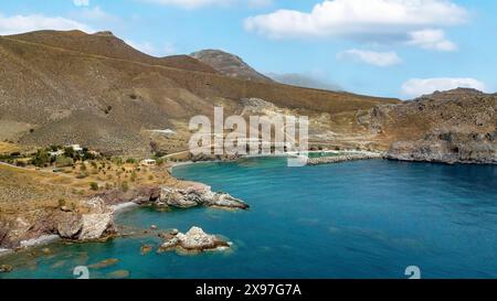 Aus der Vogelperspektive von erhöhter Position auf der linken Seite kleiner versteckter Strand Loutra Beach an der Südküste Kretas am Libyschen Meer Mittelmeer, im Hintergrund Hafen Stockfoto