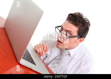 Gestresster Mann mit einer Brille auf weißem Hintergrund, der den Laptop anstarrt Stockfoto