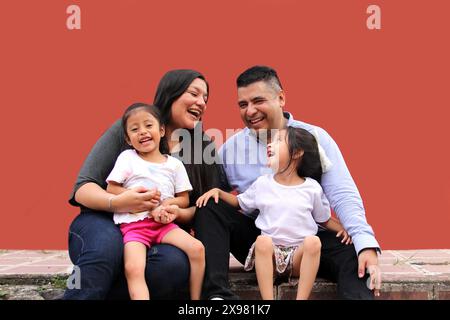 Die Familie von Vater, Mutter und zwei dunkelhäutigen Latino-Töchtern genießen eine gute gemeinsame Zeit, lachen und haben Spaß Stockfoto