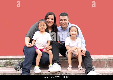 Die Familie von Vater, Mutter und zwei dunkelhäutigen Latino-Töchtern genießen eine gute gemeinsame Zeit, lachen und haben Spaß Stockfoto