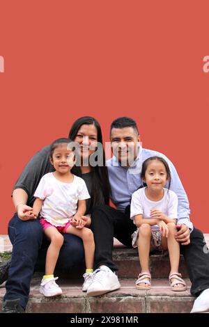 Die Familie von Vater, Mutter und zwei dunkelhäutigen Latino-Töchtern genießen eine gute gemeinsame Zeit, lachen und haben Spaß Stockfoto