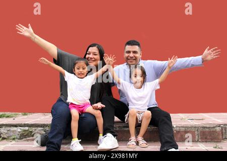 Die Familie von Vater, Mutter und zwei dunkelhäutigen Latino-Töchtern genießen eine gute gemeinsame Zeit, lachen und haben Spaß Stockfoto