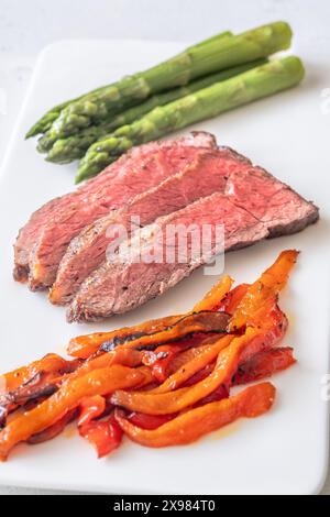 Flaches Eisensteak mit Spargel und Paprika Stockfoto