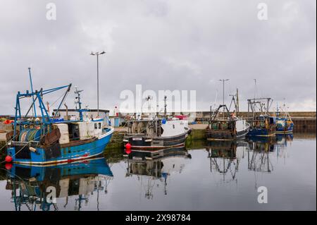 29. Mai 2024. Burghead Harbour, Moray, Schottland. Dies ist ein Blick auf die angelegten Fischerboote, die auf einer ruhigen, aber grauen Wolke am Pier von Burghead Harbour befestigt sind Stockfoto