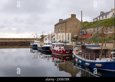 29. Mai 2024. Burghead Harbour, Moray, Schottland. Dies ist ein Blick auf die angelegten Fischerboote, die auf einer ruhigen, aber grauen Wolke am Pier von Burghead Harbour befestigt sind Stockfoto