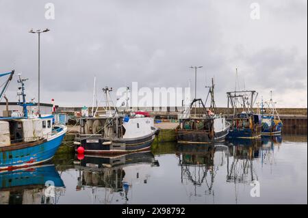 29. Mai 2024. Burghead Harbour, Moray, Schottland. Dies ist ein Blick auf die angelegten Fischerboote, die auf einer ruhigen, aber grauen Wolke am Pier von Burghead Harbour befestigt sind Stockfoto