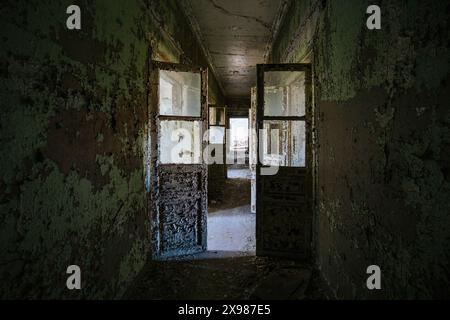 Korridor mit abgeblätterter Farbe in einem alten verlassenen Gebäude. Stockfoto