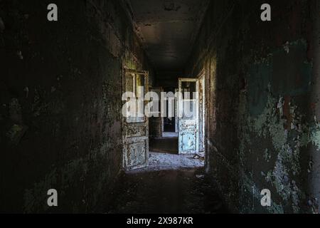 Korridor mit abgeblätterter Farbe in einem alten verlassenen Gebäude. Stockfoto