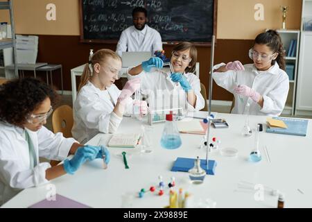 Multiethnische Gruppe von Kindern, die während des Chemieunterrichts in der Schule Laborexperimente machen, Hochwinkelaufnahme Stockfoto