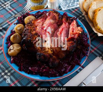 Gebratene Schweinshaxe mit geschmortem Kohl Stockfoto