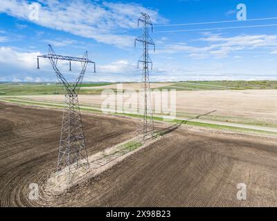 Elektrische Sendetürme sind ein Luftbild mit Blick auf landwirtschaftliche Felder und Landstraße im Rocky View County Alberta Kanada. Stockfoto