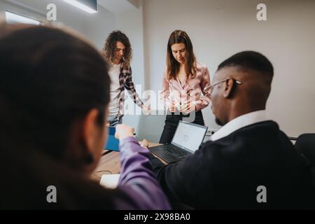 Das vielfältige Team arbeitet in einem modernen Büroumfeld zusammen und führt kreative Projektdiskussionen durch Stockfoto