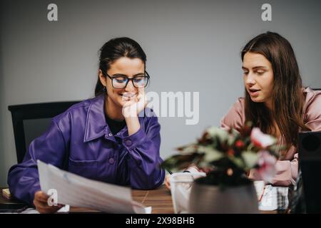 Zwei professionelle Frauen nehmen an einem Geschäftstreffen Teil und diskutieren Dokumente in einem Büro Stockfoto