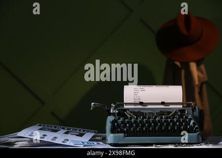 Retro-Schreibmaschine, gesuchtes Poster, Handschellen und Dokument des FBI-Agenten auf dem Tisch vor der Farbwand Stockfoto