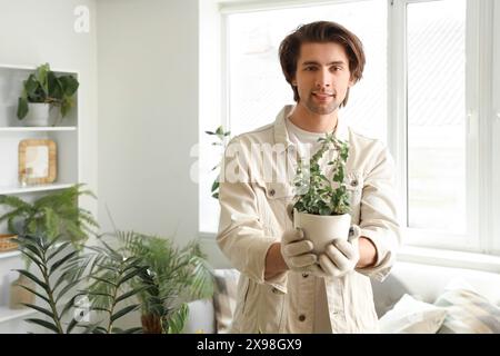 Schöner Gärtner mit Pflanzen zu Hause Stockfoto