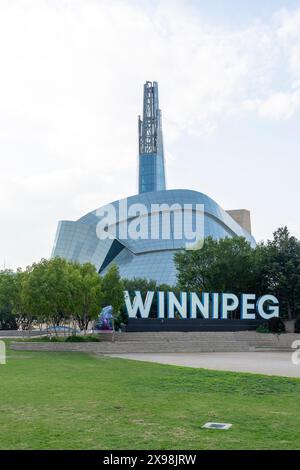 WINNIPEG-Schild mit kanadischem Museum für Menschenrechte im Hintergrund in Winnipeg, Manitoba, Kanada Stockfoto