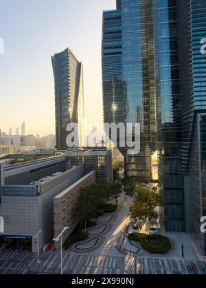 Sonnenuntergang über Abu Dhabis Skyline von Al Maryah Island, Vereinigte Arabische Emirate. Die leuchtenden Farben der untergehenden Sonne erhellen das moderne Archi Stockfoto