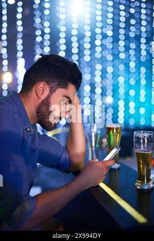 Mann, Nacht und Club oder aufgebracht mit Smartphone, antisozial und scrollen online mit Alkohol oder Bar Party. SMS, Wochenende und Aufregung und Lesen Stockfoto