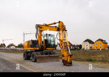 Gelber Bagger auf einer verlassenen Baustelle. Grau bewölkter Himmel. Stockfoto