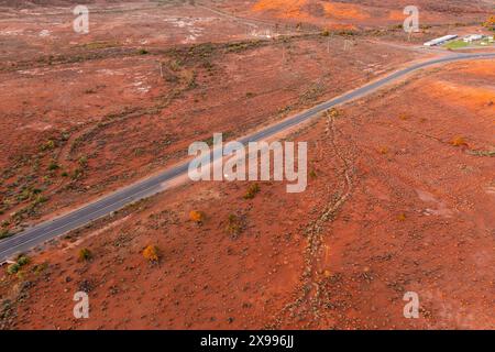 Aus der Vogelperspektive einer schmalen Straße durch eine trockene Outback-Landschaft am Broken Hill im Outback New South Wales, Australien Stockfoto