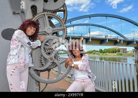 29. Mai 2024, Brandenburg, Frankfurt (oder): Die bekannten Zwillinge aus Frankfurt (oder), Heike Guderian (l) und Heidi Kapuste, stehen an der oder mit der Stadtbrücke im Hintergrund. Foto: Patrick Pleul/dpa Stockfoto