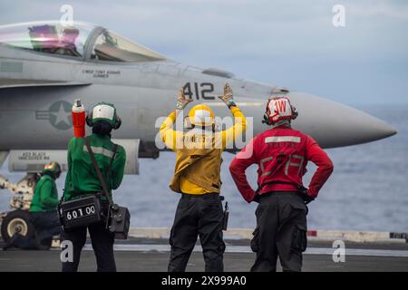 Philippine Sea, Usa. Oktober 2023. US-Navy-Seeleute signalisieren dem Piloten eines F/A-18E Super Hornet Jagdflugzeugs, das an der Dambusters of Strike Fighter Squadron 195 befestigt ist, vom Flugdeck des Nimitz-Klasse-Flugzeugträgers USS Ronald Reagan zu starten, der am 21. Mai 2024 im Südchinesischen Meer unterwegs ist. Beschreibung: MC2 Keyly Santizo/US Navy Photo/Alamy Live News Stockfoto