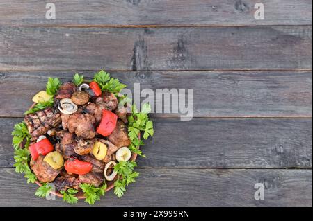 Fleisch mit Gemüse und Pilzen mit Kräutern auf einem Teller. Schweinerippchen werden auf dem Grill gekocht. Stockfoto