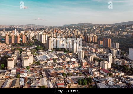 Blick aus der Vogelperspektive auf Caracas bei Sonnenuntergang mit dem David Tower Wahrzeichen Wolkenkratzer und Slums sichtbar. Drohnenaufnahme der venezolanischen Hauptstadt bei Sonnenuntergang. Konzept o Stockfoto