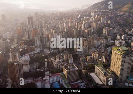 Blick aus der Vogelperspektive auf Caracas bei Sonnenuntergang mit dem David Tower Wahrzeichen Wolkenkratzer und Slums sichtbar. Drohnenaufnahme der venezolanischen Hauptstadt bei Sonnenuntergang. Konzept o Stockfoto