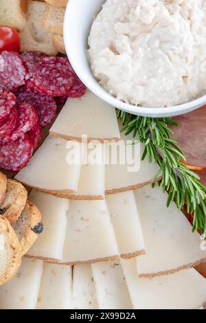Auswahl an Käse- und Wurstscheiben auf einer Wurstplatte, die für ein gemeinsames kulinarisches Erlebnis vorbereitet wird, flache Aufschnitt-Präsentation Stockfoto