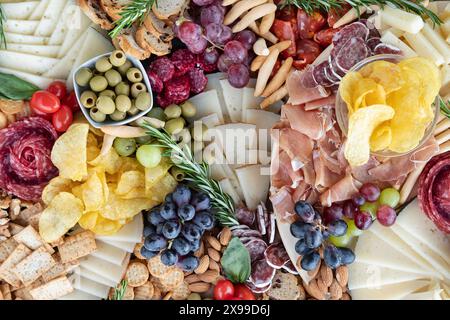 Raffinierte Wurstplatte mit einer Auswahl an Wurstwaren, Käse, Oliven, Crackern, Trauben, Nüsse, Kirschtomaten und frische Rosmarinquellen Stockfoto